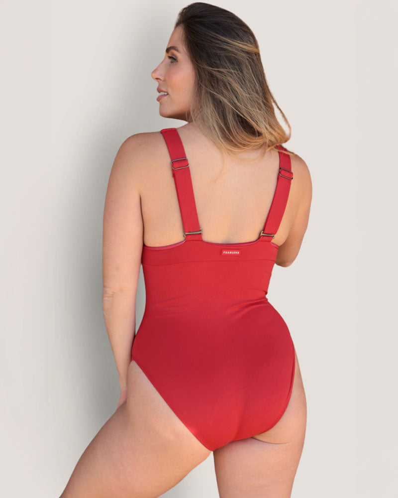 Woman wearing a full coverage, supportive bust red one piece swimsuit.
