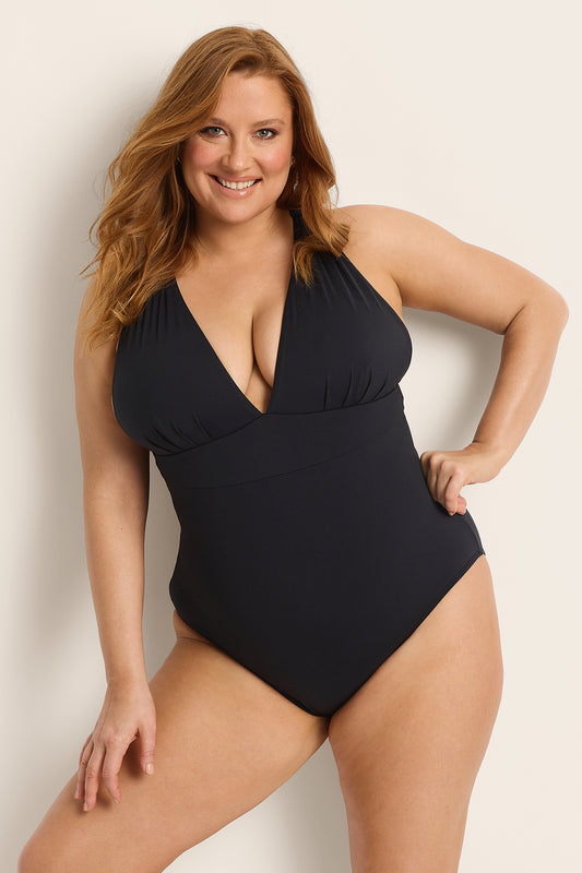 A woman with long red hair smiles confidently in the Fearless au All Day One Piece - Matte Black/Long, featuring a deep V-neckline and built-in bust support, against a light background.