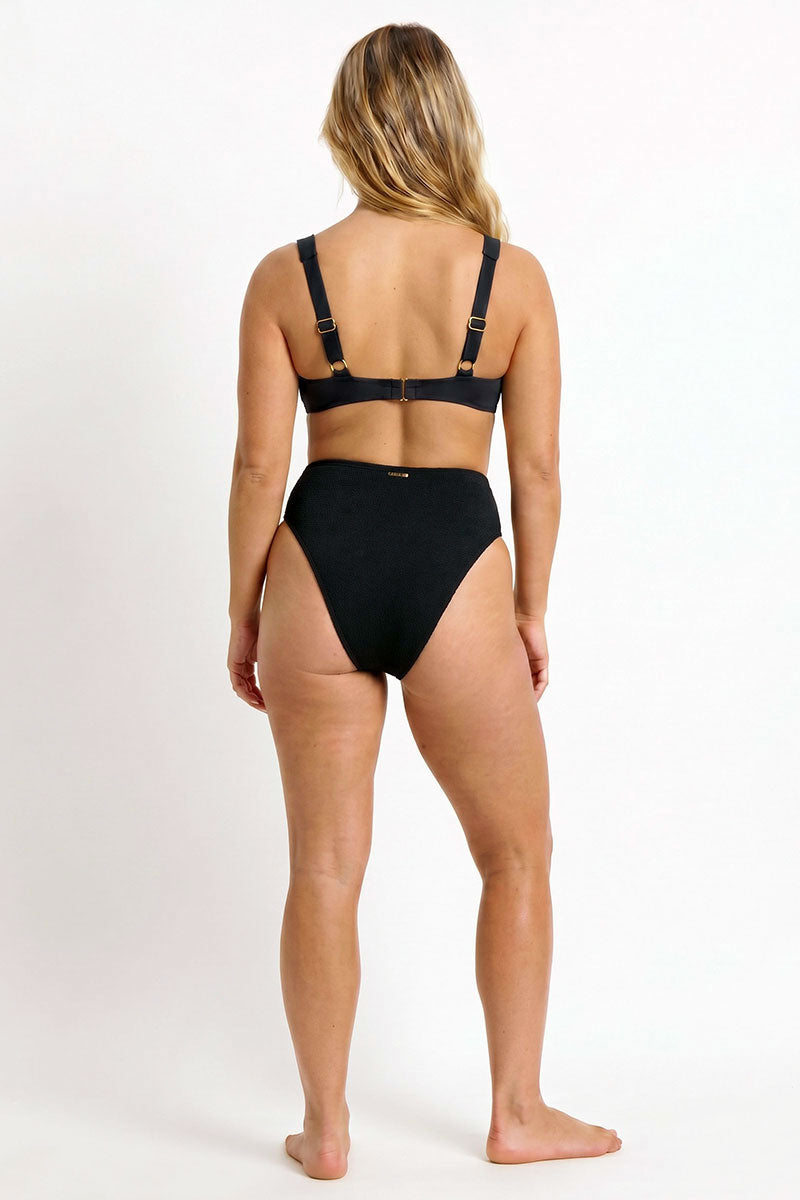 Woman wearing a black bikini on a white background
