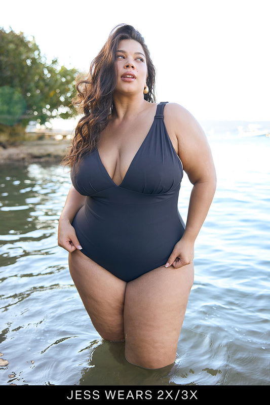 Woman in a black swimsuit standing in water with text indicating size 2X/3X.