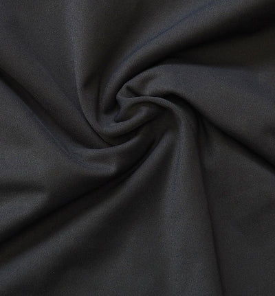 A close-up of black fabric with a soft, slightly lustrous texture, arranged in a central swirl drape.