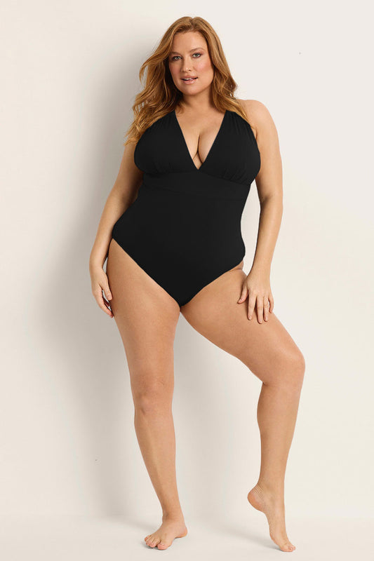 A woman with long red hair smiles confidently in the Fearless au All Day One Piece - Matte Black/Long, featuring a deep V-neckline and built-in bust support, against a light background.