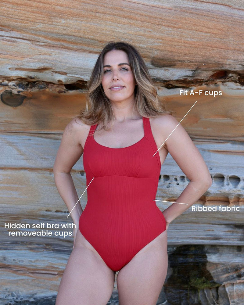 Woman wearing a red swimsuit with text highlighting features against a wooden background