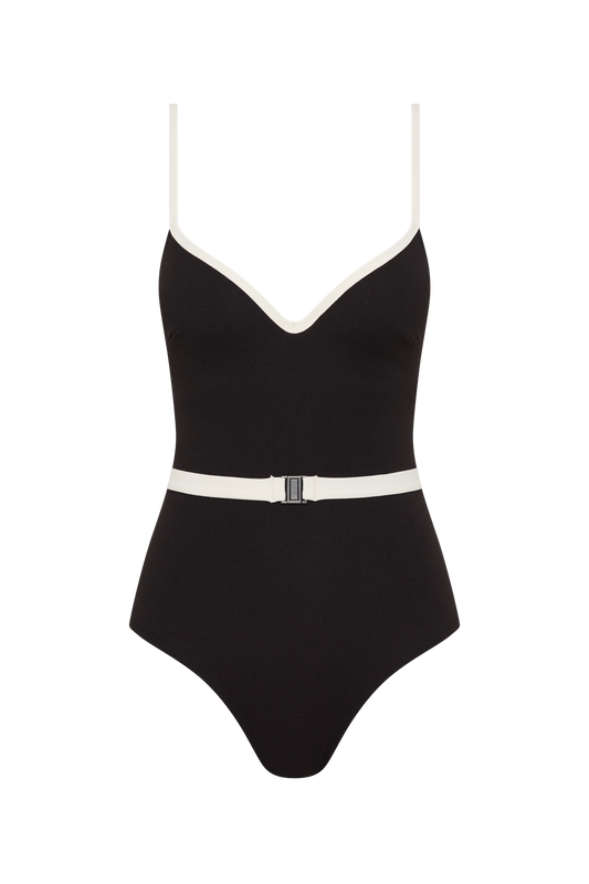 The Grace High Rise by Fearless au is a matte black one-piece swimsuit with moulded cups, white trim on the straps and neckline, a white belt with a black buckle at the waist, and a flattering high-cut leg.