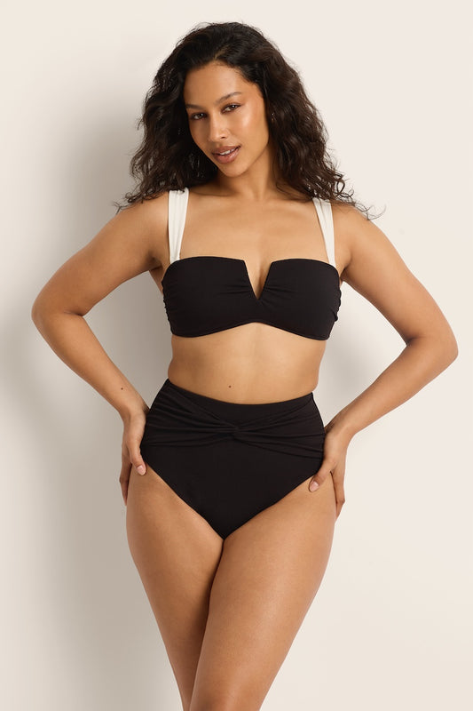 Woman wearing a black bikini against a plain background