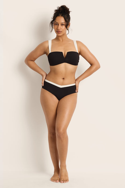 Woman wearing a black bikini against a plain background