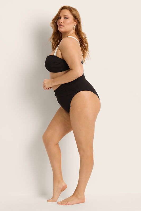 Woman wearing a black bikini against a plain background