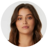 Portrait of a young woman with long brown hair, neutral expression, and light skin, shown against a plain light background within a circular frame.