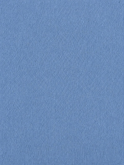 A close-up texture shot of a solid medium blue fabric or material surface.