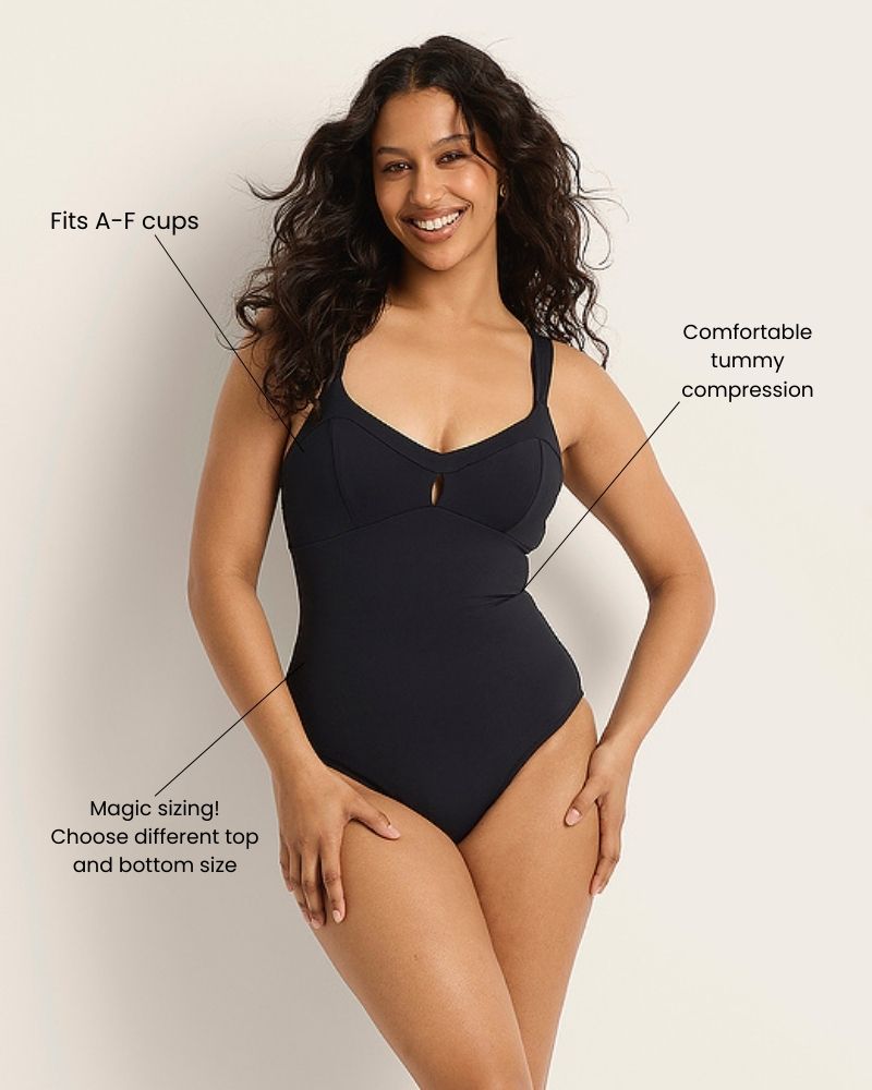 A smiling woman wears a black one-piece swimsuit. Text points to features: Fits A–F cups, Comfortable tummy compression, and Magic sizing! Choose different top and bottom size.