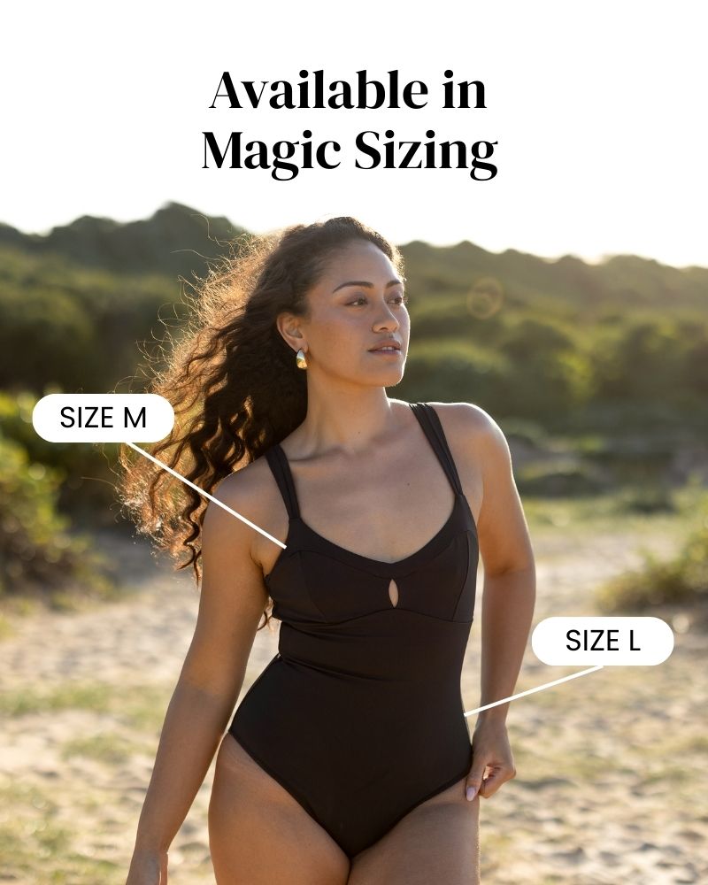 A woman outdoors wears a black one-piece swimsuit. Text reads Available in Magic Sizing, with arrows pointing to her body labeled Size M and Size L, showing the swimsuits flexibility.